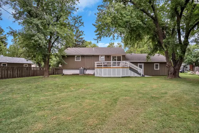 Spacious backyard with a large wooden deck and white railings.