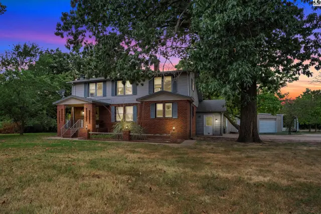 Two-story brick and siding home with a covered porch and attached garage.