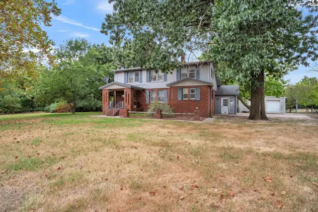 Two-story brick and siding home with a covered front porch and detached garage.