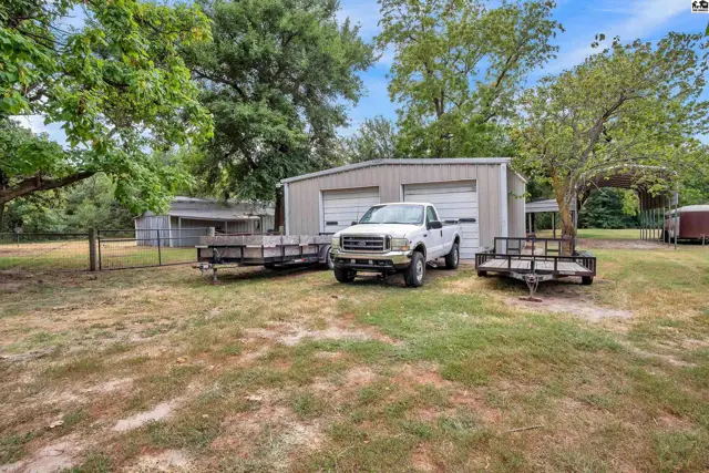 Metal garage with two bay doors and a white pickup truck parked in front.