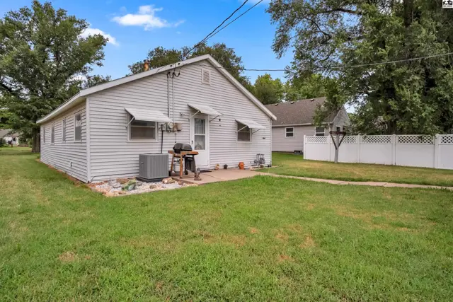 Exterior features a white vinyl-sided house with a small patio and air conditioning unit.