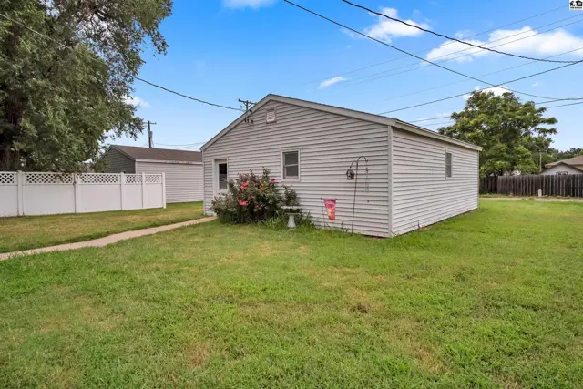 This single-story home features white vinyl siding and a grassy yard.