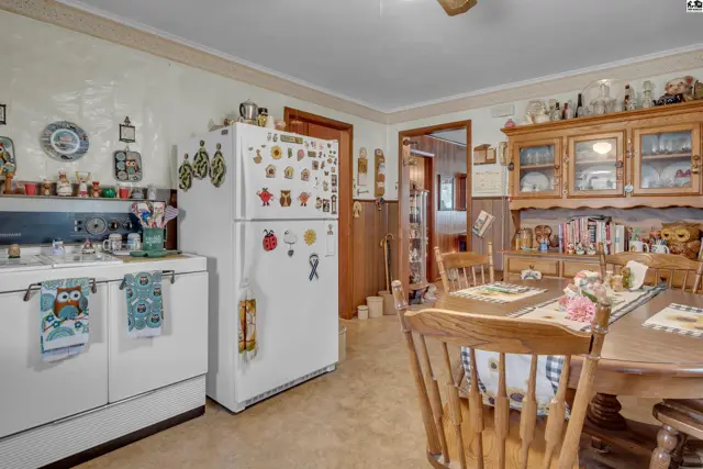 Kitchen features a white refrigerator, vintage stove, and wooden cabinetry.