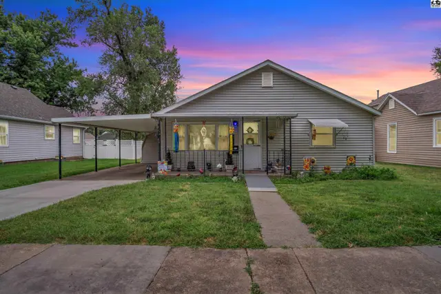This single-story home features a covered front porch and a detached carport.