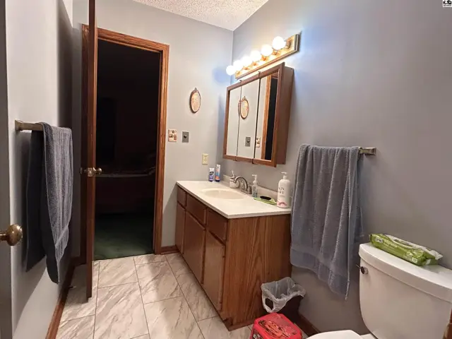 This bathroom features a double vanity, tiled floor, and a mirrored medicine cabinet.