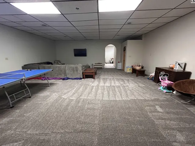 Spacious finished basement with carpet, recessed lighting, and an open layout.