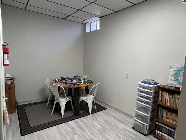 Room with a table, chairs, storage units, and a bookshelf.