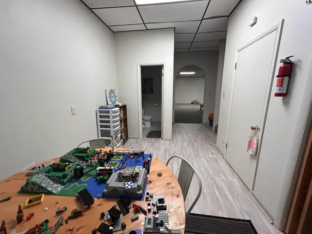 This room features a round table with a built-in toy structure, a small bathroom, and a hallway.