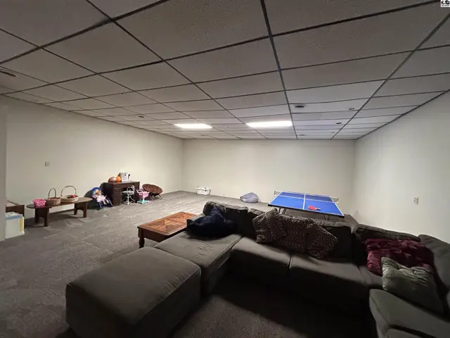 Spacious finished basement with carpet, drop ceiling, and ample room for recreation.