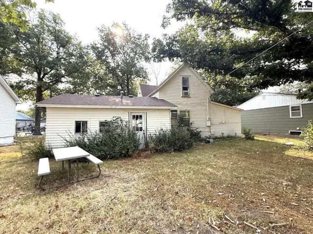 A detached garage with a picnic table sits in the grassy yard.