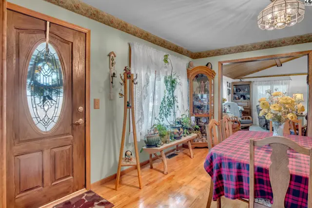 Wood floors and a glass-paneled door lead to a dining area with a hutch.