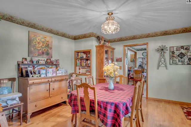 This dining room features a wooden table with a checkered tablecloth and a built-in bookshelf.