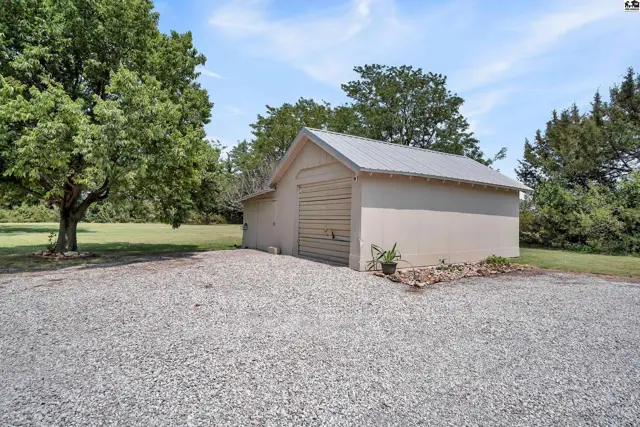 This detached garage features a metal roof and a roll-up door.