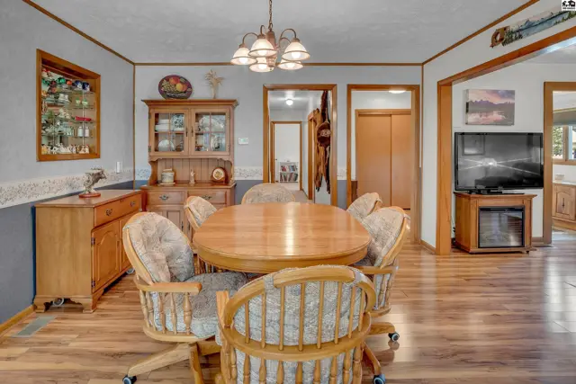 This dining area features a wooden table, upholstered chairs, and a built-in hutch.