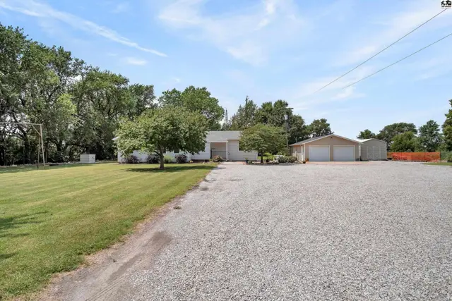 This property features a main house, a detached garage, and a storage building.
