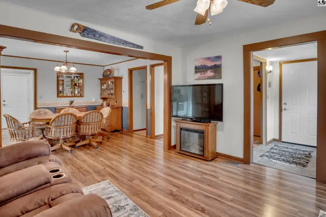 Wood-look flooring extends through this living area, dining room, and entryway.
