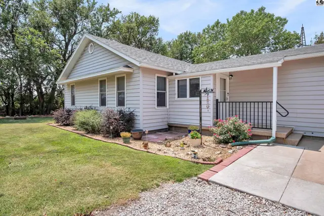 Light gray siding and white trim adorn this single-story home with a covered porch.