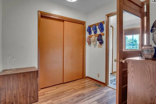 Wood-look flooring complements a closet with sliding doors and a wooden dresser.