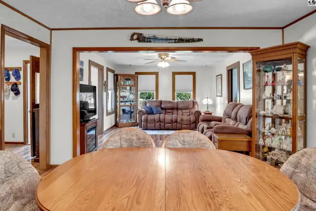 Spacious living area with a dining table, display cabinet, and comfortable seating.
