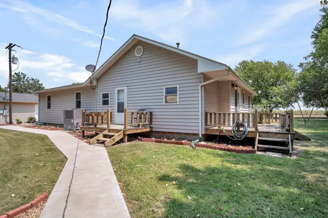 This single-story home features light-colored siding and a wooden deck.