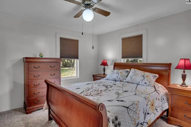 This bedroom features a wooden bed frame, dresser, and nightstands.