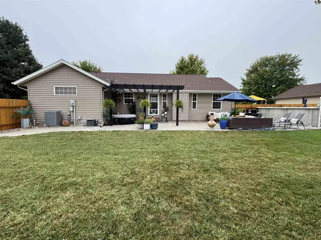 A spacious backyard features a patio, pergola, hot tub, and swimming pool.