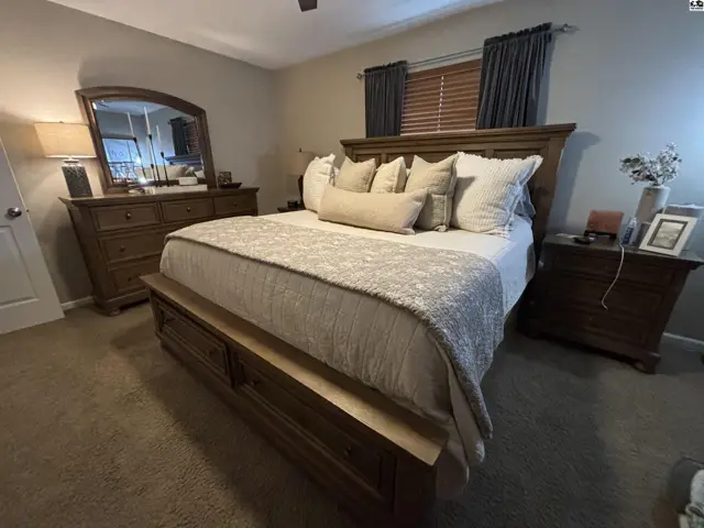 Spacious bedroom features a king-size bed, dresser, and nightstands.