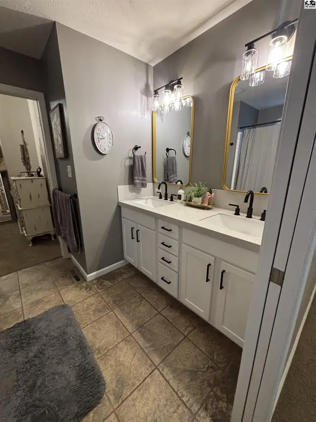 This bathroom features a double vanity with white cabinets and a quartz countertop.