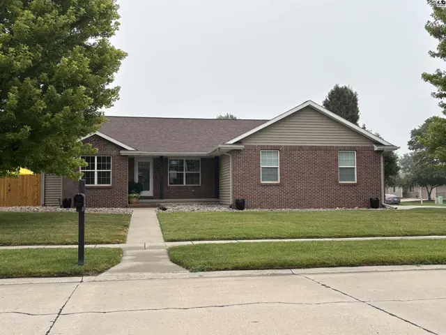Brick ranch home with a covered front porch and attached two-car garage.