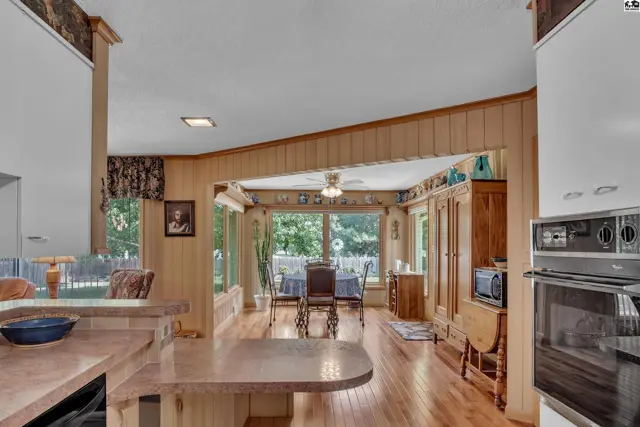 Wood-paneled walls and a built-in hutch accent this dining area with large windows.