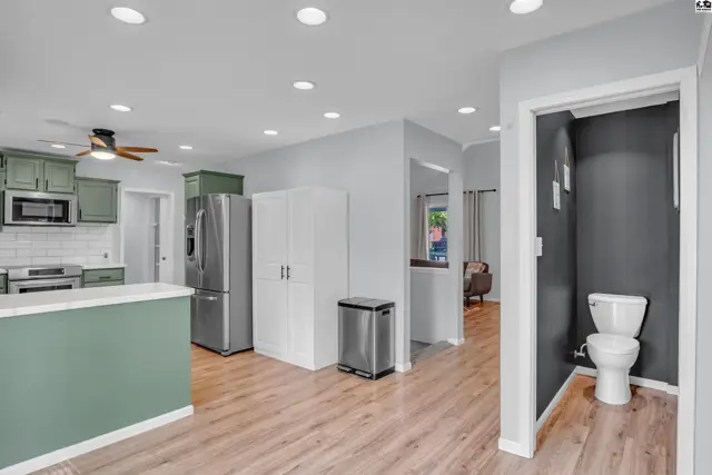 Spacious kitchen with stainless steel appliances and a light wood-look floor.