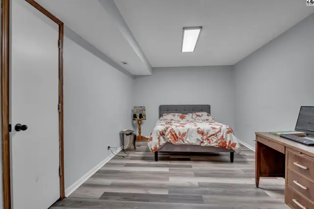 This room features a bed, desk, and a door with a silver knob.