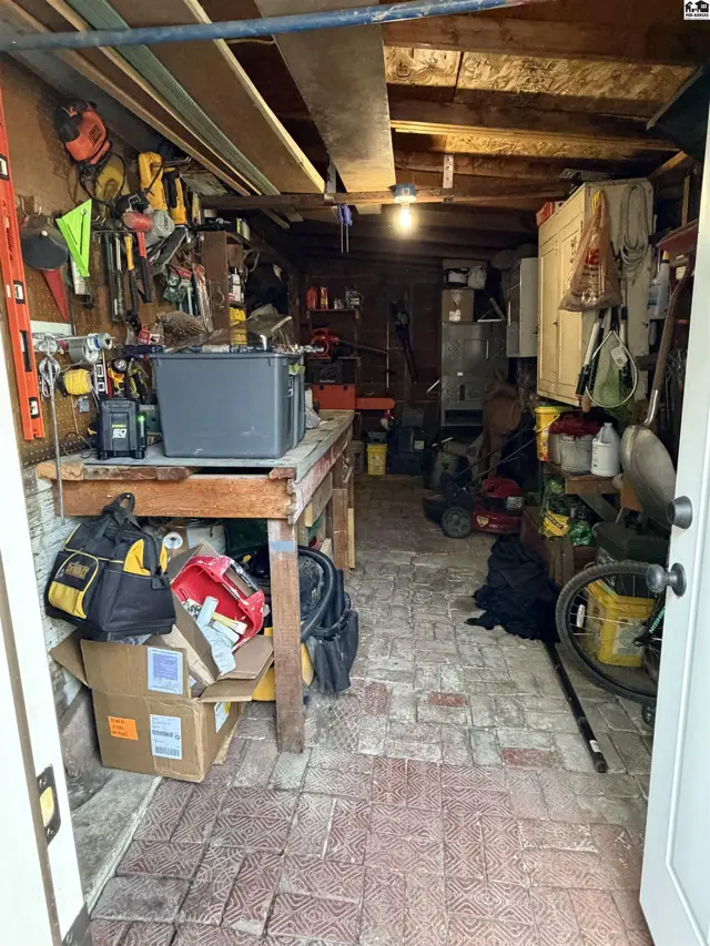 Workshop with a workbench, brick floor, and ample storage for tools.