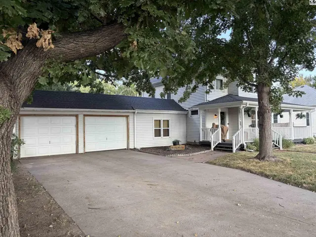 White siding house with a white porch and a two-car garage.