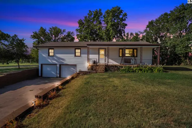 White siding ranch home with a two-car garage and a covered front porch.