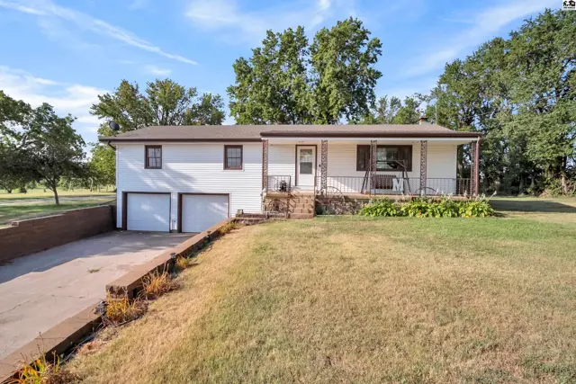 White-sided ranch home with a covered front porch and attached two-car garage.