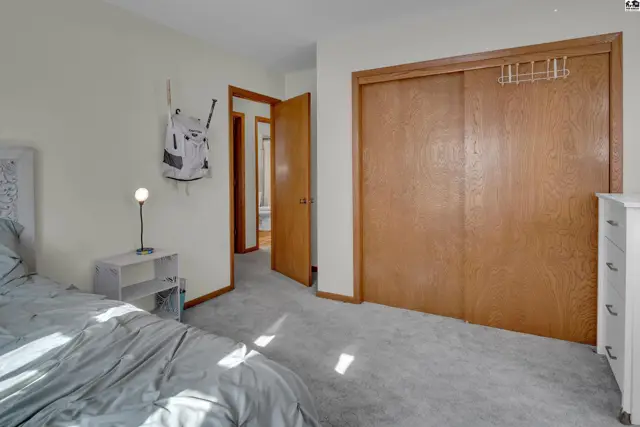 This bedroom features a closet with sliding wood doors and a white dresser.