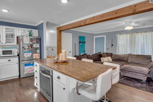 Kitchen island with seating overlooks a living area with a sectional sofa.