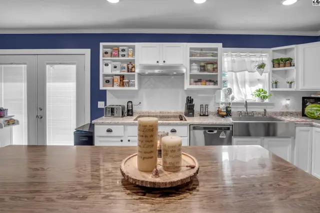White cabinetry and stainless steel appliances complement a large island in this spacious kitchen.