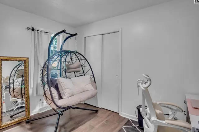This room features white walls, a closet with sliding doors, and a hanging chair.