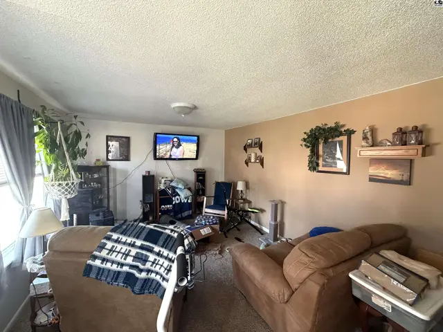 Living room features two sofas, a television, and a large window.