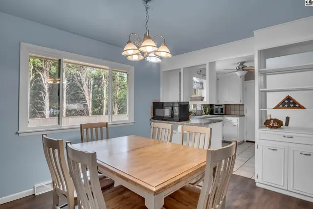 Light blue walls and a wood table complement this dining area with built-in shelving.