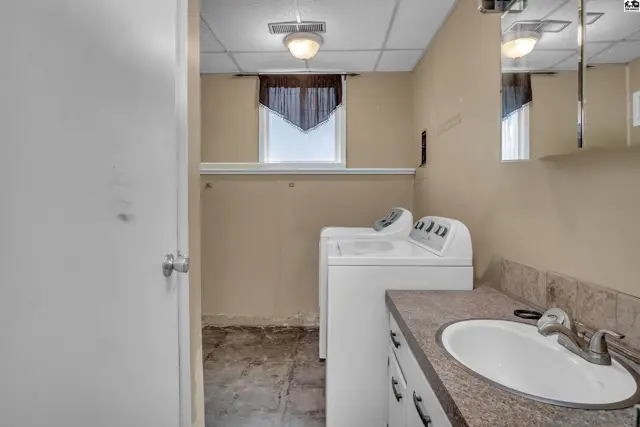 This laundry room features a sink, countertop, washer, and dryer.