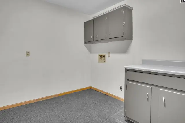 This room features grey cabinets, a countertop, and grey carpet.