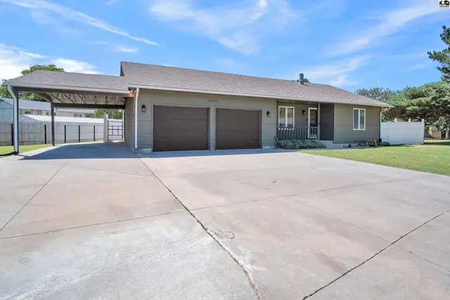 This home features a two-car garage, a covered carport, and a paved driveway.