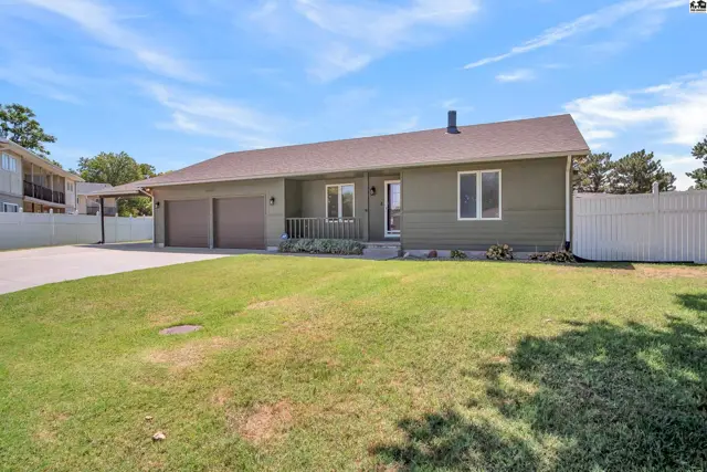 This single-story home features a two-car garage and a covered carport.