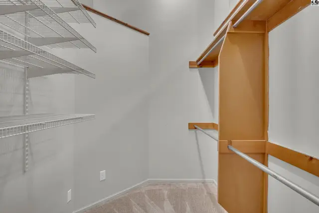 Spacious walk-in closet with built-in shelving and hanging rods.