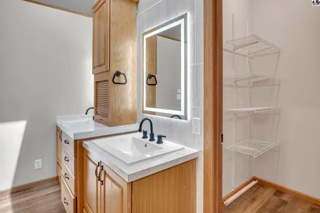 This bathroom features a double vanity with white countertops and modern black fixtures.