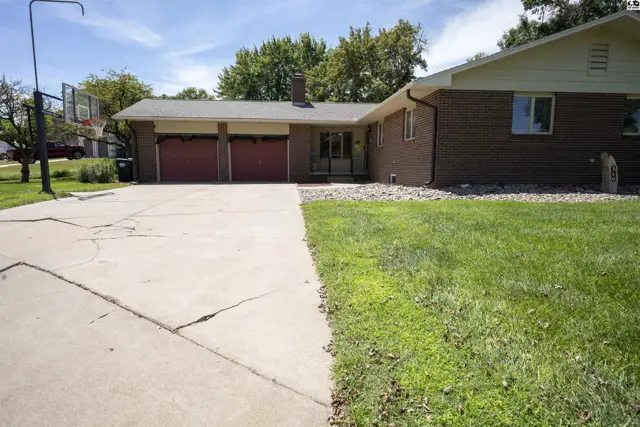 Brick ranch home with a three-car garage and basketball hoop.