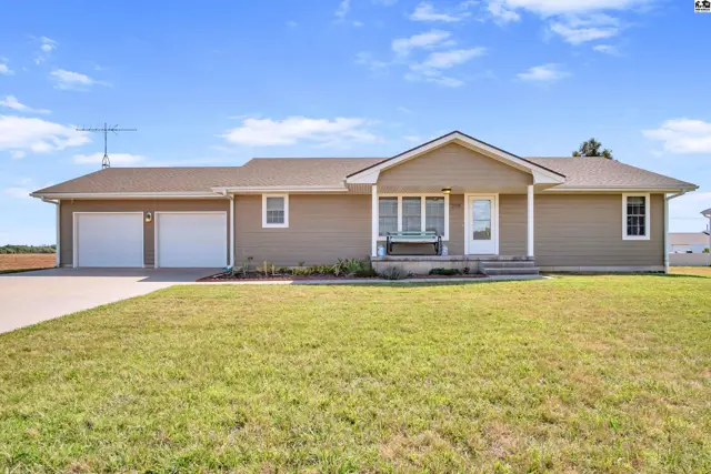 This tan ranch-style home features a covered front porch and an attached two-car garage.
